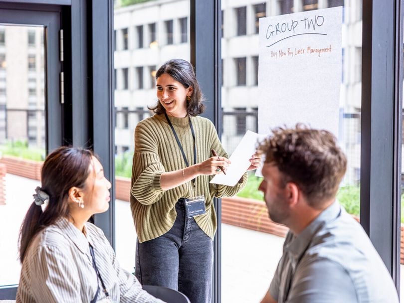 Three Narmi team members collaborating on a project together in the company’s office